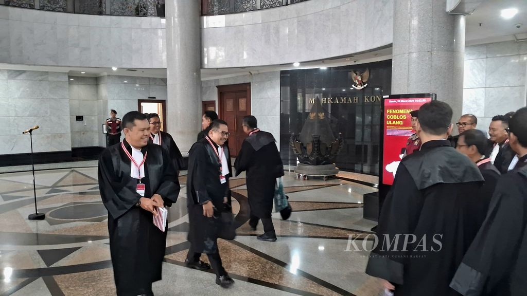 Tim kuasa hukum Komisi Pemilihan Umum (kiri) berpapasan dengan tim kuasa hukum Prabowo Subianto-Gibran Rakabuming Raka saat bergantian memberikan keterangan pers seusai sidang perselisihan hasil pemilihan umum pemilihan presiden dan wakil presiden di Mahkamah Konstitusi, Jakarta, Jumat (28/3/2024). 