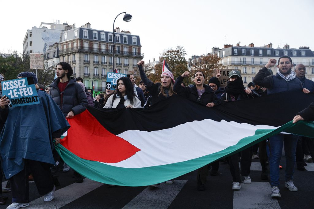 Pengunjuk rasa membentangkan bendera Palestina saat demonstrasi solidaritas terhadap rakyat Palestina di Paris, Perancis, 4 November 2023. 