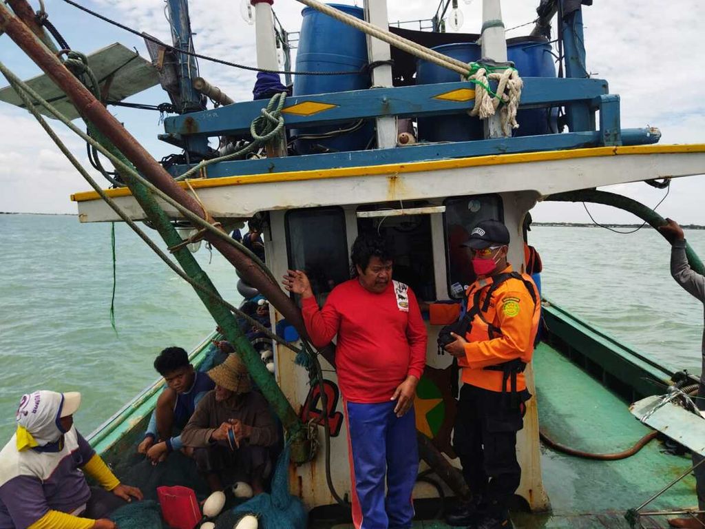 Petugas SAR berkomunikasi dengan nelayan di Kapal Motor Putra Barokah SN di perairan Karawang, Jawa Barat, Selasa (8/3/2022). Kapal berisi 19 orang itu sebelumnya dinyatakan hilang kontak, Minggu (6/3/2022).