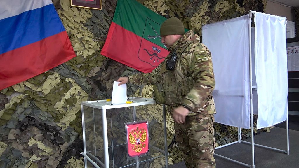 Seorang prajurit Rusia memberikan suara untuk pemilihan presiden lebih awal di wilayah Zaphorizhia yang dikuasai Rusia di Ukraina timur, Senin (11/3/2024).