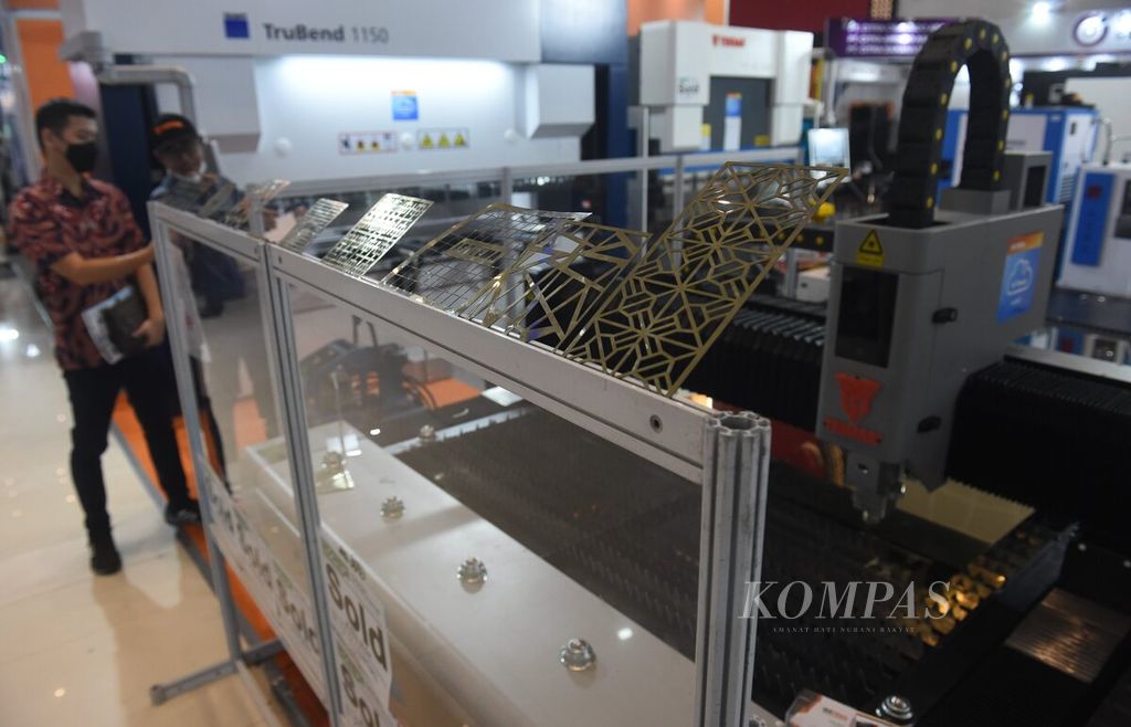 Pengunjung melihat mesin pencetak pelat besi saat Pameran Internasional ke-17 Manufacturing Surabaya di Grand City Convention & Exhibition, Surabaya, Jawa Timur, Jumat (14/7/2023). 