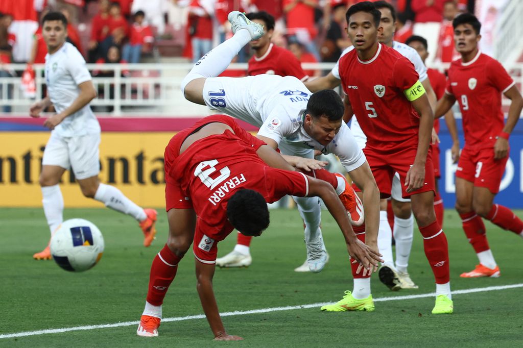 Uzbekistan defender, Alibek Davronov (center), and Indonesian defender, Muhammad Ferarri (front), compete for the ball in the semifinal match of the 2024 AFC U-23 Cup in Abdullah bin Khalifa Stadium, Doha, on Monday (29/4/2024) night.