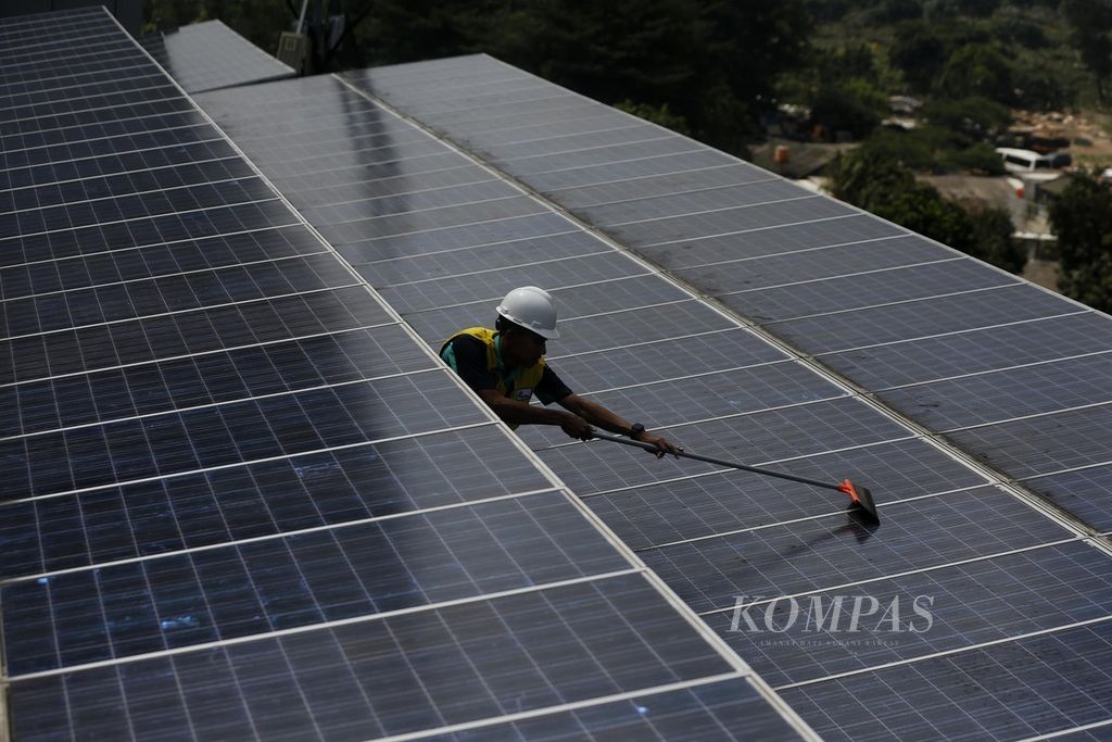 Teknisi merawat panel surya yang terpasang di atap gedung Direktorat Jenderal Ketenagalistrikan Kementerian ESDM, Jakarta, Jumat (5/5/2023).