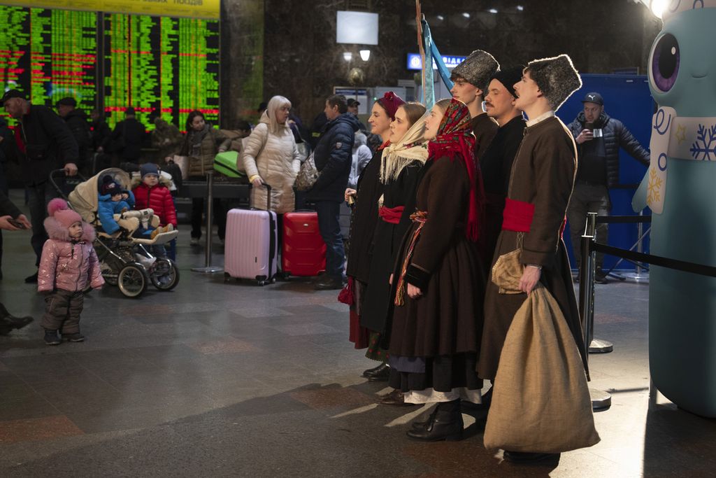 Para seniman berpakaian nasional menyanyikan lagu-lagu Natal dalam pertunjukan Natal beberapa hari sebelum Natal di stasiun kereta api pusat kota di Kyiv, Ukraina, pada 21 Desember 2023. 