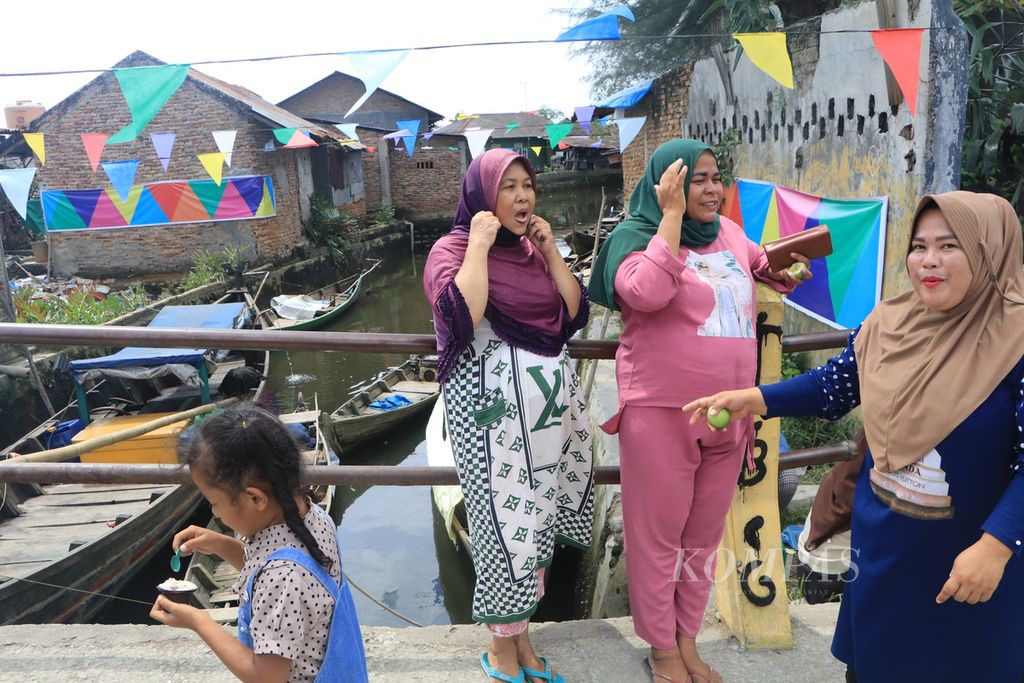 Para puan <i>paloh </i>atau perempuan pesisir menyaksikan Festival Payau Puan Paloh di Kelurahan Paya Pasir, Medan, Sumatera Utara, Sabtu (11/3/2023). Para perempuan pesisir juga bermain teater, puisi, dan bernyanyi dalam festival itu. 