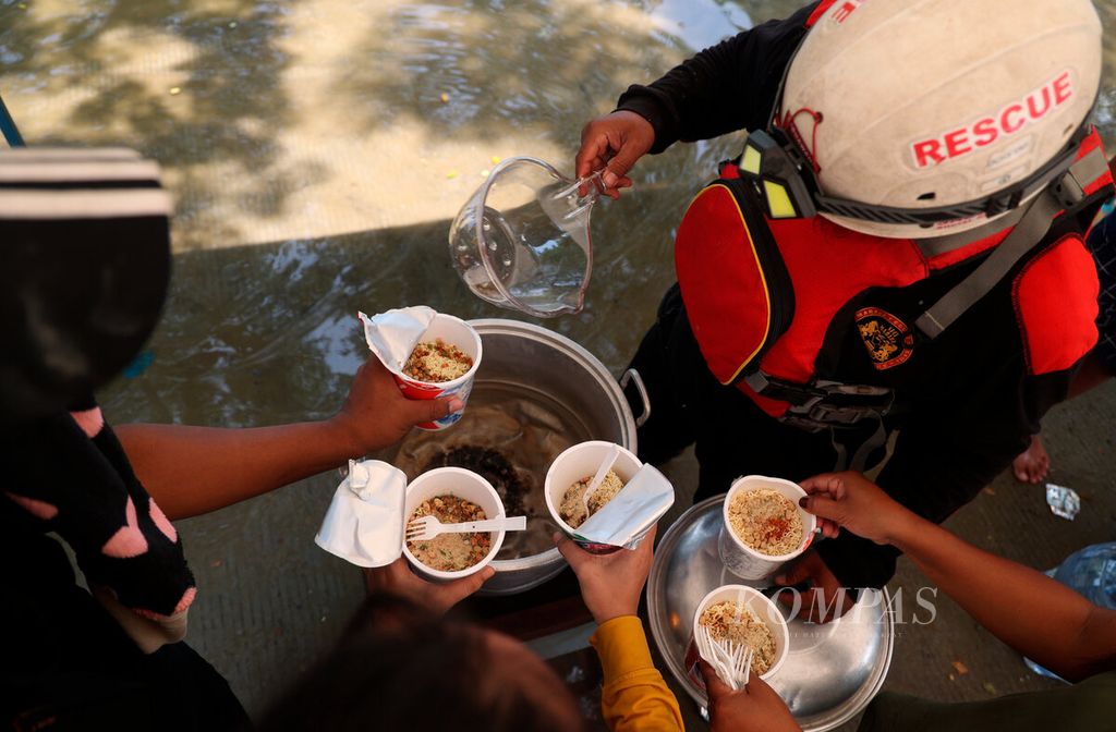 Sukarelawan membagikan makanan gratis bagi warga korban banjir di Kecamatan Karangtengah, Kabupaten Demak, Jawa Tengah, Kamis (15/2/2024).