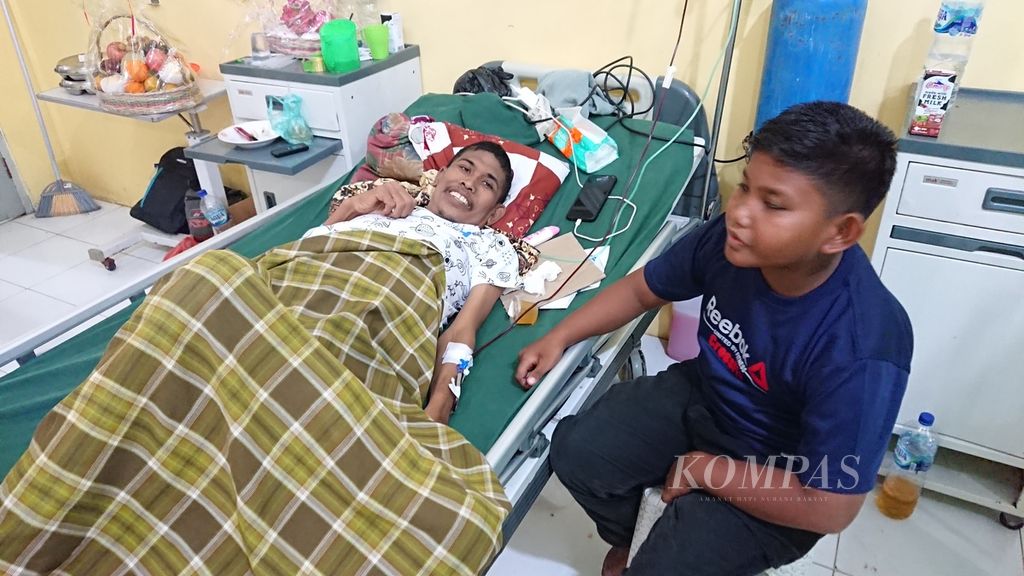 Rusli Yusuf (46) ditemani anaknya, Rahmat Aulia (11), saat dalam perawatan Rumah Sakit Umum Daerah (RSUD) Cut Meutia, Kabupaten Aceh Utara, Senin (30/1/2023). Rusli mengalami gangguan sel hati sehingga harus menjalani perawatan medis yang panjang. Namun, dia mendapatkan pelayanan gratis melalui program Jaminan Kesehatan Aceh.