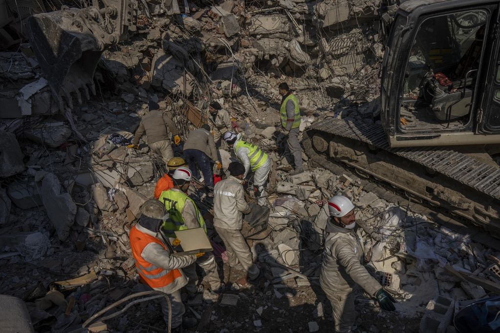  Anggota tim pencari dan penyelamat (SAR) berupaya mencari korban gempa di reruntuhan gedung yang ambruk di Antakya, Turki tenggara, Minggu (12/2/2023). 