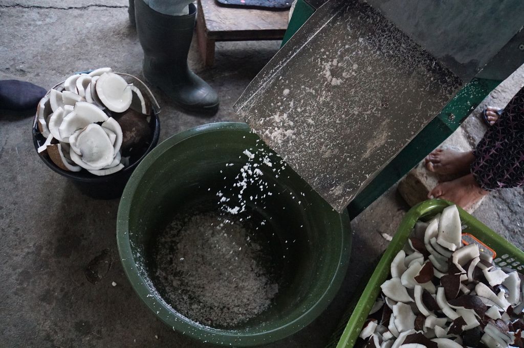 Parutan kelapa ditampung dalam ember sebelum diolah menjadi minyak kelapa, Kamis (16/4/2020), di unit pengolahan minyak kelapa Ezer Kenegdo, Desa Jayakarsa, Likupang Barat, Minahasa Utara, Sulawesi Utara.