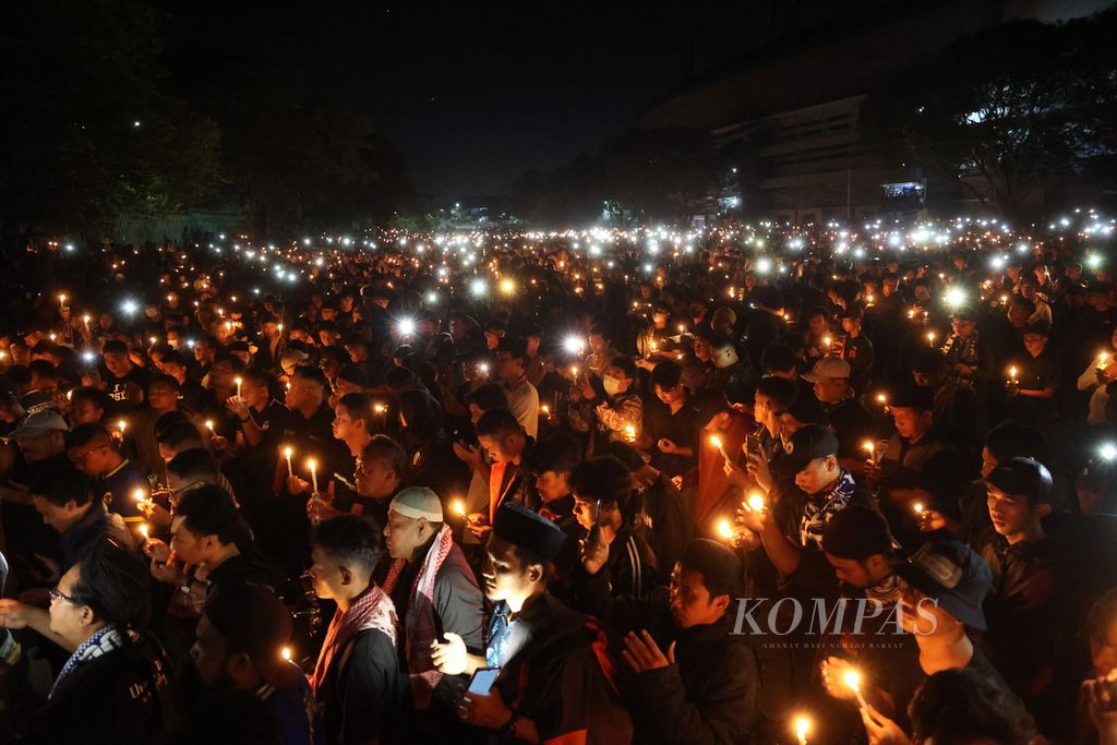 Suporter dari sejumlah tim sepak bola melakukan doa bersama untuk mendoakan para korban Tragedi Kanjuruhan di Stadion Mandala Krida, Yogyakarta, 4 Oktober 2022 malam. 