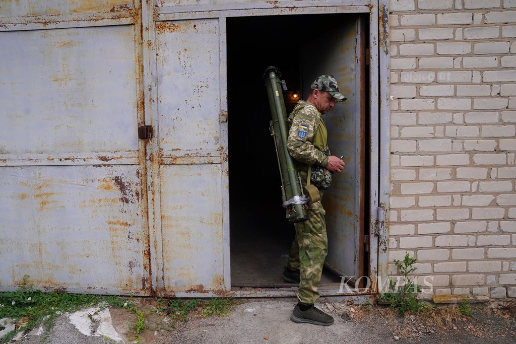 Seorang milisi memanggul dua senjata anti-tank keluar dari sebuah gudang senjata di bagian selatan Ukraina, Rabu (22/6/2022). Perang Ukraina-Rusia masih terus berkecamuk di bagian timur dan selatan Ukraina lewat pertempuran artileri dan serangan rudal. 