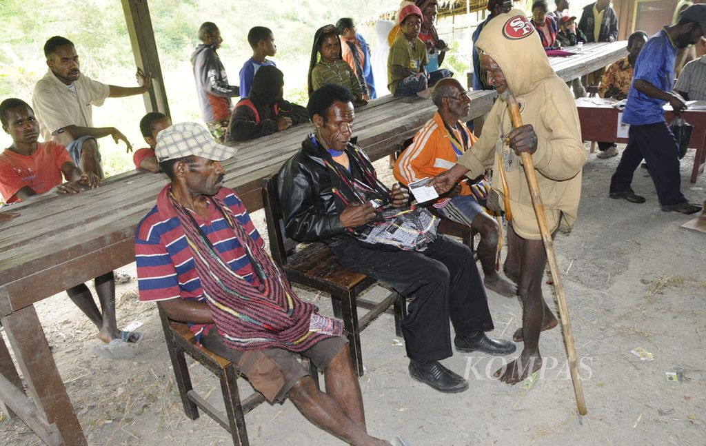 Warga menggunakan hak suaranya di TPS Eroma 1, Distrik Kurima, Kabupaten Yahukimo, Papua. Pemilih bernama Tenyo Wake memasukkan surat suara pemilihan presiden ke dalam noken (tas kantong tradisional) yang merepresentasikan calon presiden pilihannya, Rabu (8/7/2009). 