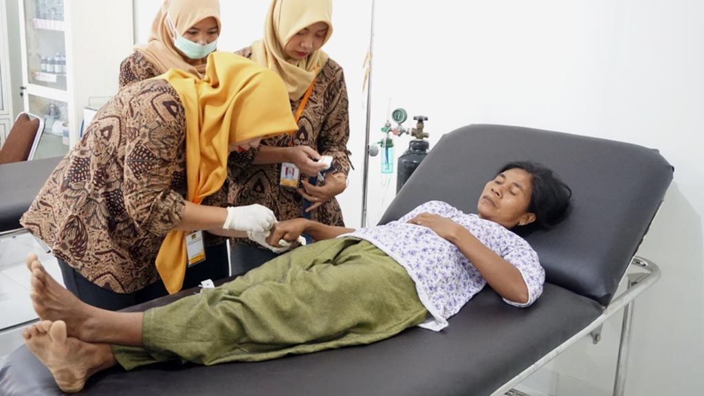 Seorang pasien dirawat di ruang unit gawat darurat Puskesmas Nipah, Desa Malaka, Lombok Utara, Nusa Tenggara Barat, Rabu (24/4/2019). Puskesmas yang rusak akibat gempa itu dibangun kembali menggunakan dana bantuan yang dihimpun dari pembaca harian <i>Kompas</i>.