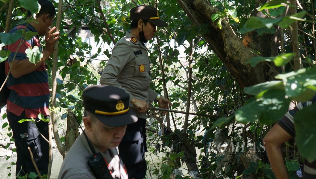 Aparat kepolisian tengah mencari potongan tubuh manusia di tepi Sungai Pringgolayan, Kecamatan Serengan, Kota Surakarta, Jawa Tengah, Senin (22/5/2023).