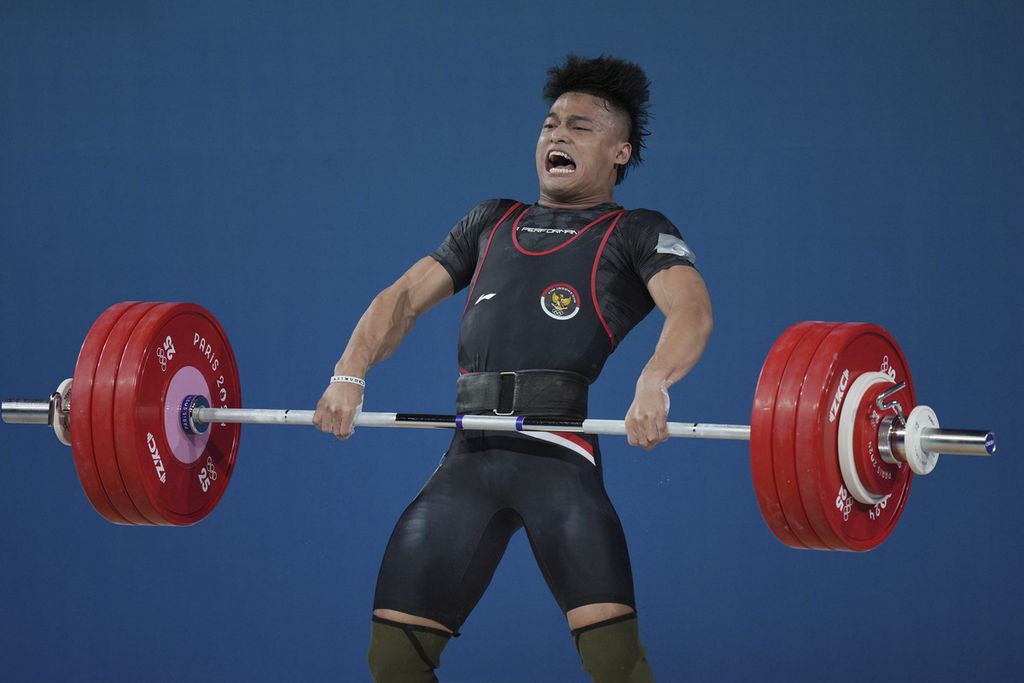 Lifter Indonesia, Rizki Juniansyah, saat tampil pada cabang angkat besi kelas 73 kilogram Olimpiade Paris 2024 di Paris, Perancis, Jumat (9/8/2024) dini hari WIB. Rizki berhasil merebut medali emas.