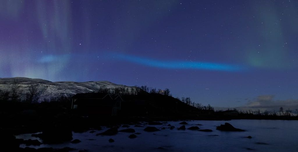 Citra aurora biru yang terlihat di atas Danau Tornetrask, utara Swedia, oleh Claudio Comi pada 4 November 2022. Foto ini kemudian diunggah ke situs Space Weather.