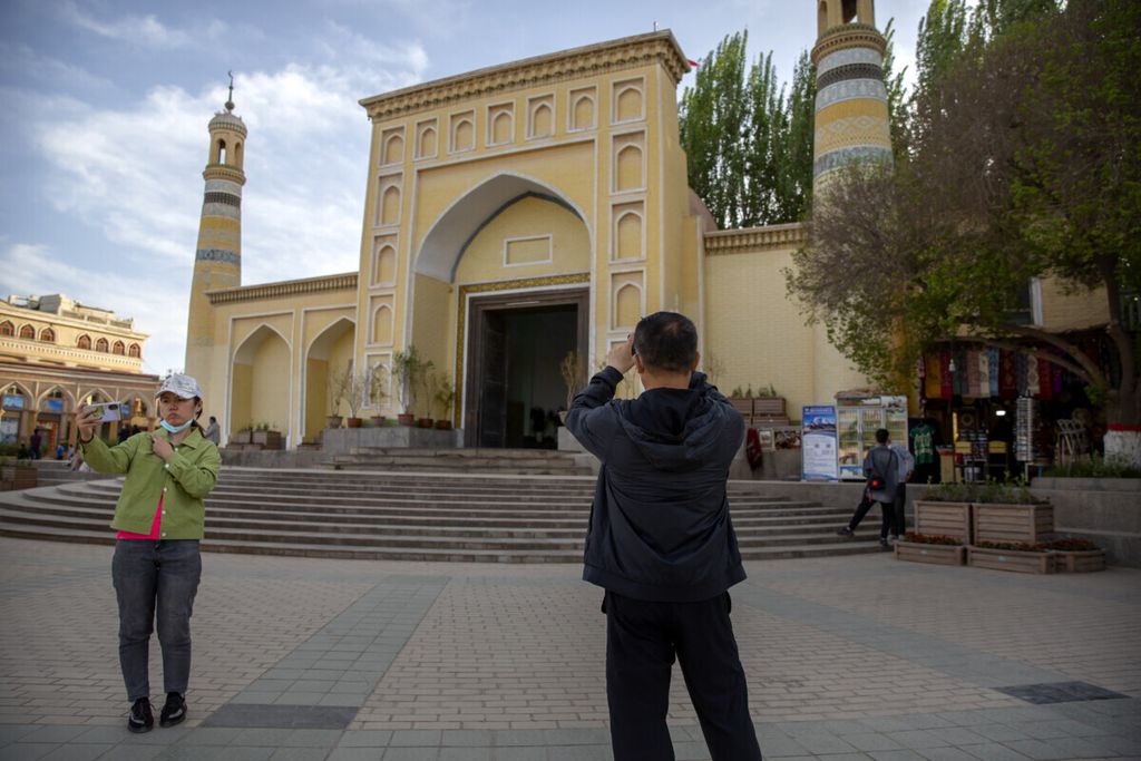 Wisatawan berfoto di depan Masjid Id Kah yang terletak di kota Kashgar, Provinsi Xinjiang, China, 19 April 2021.