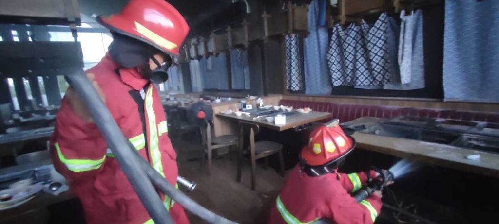 Petugas Dinas Pemadam Kebakaran Kota Bekasi memadamkan api di salah satu restoran di Perum Summarecon, Kota Bekasi, Jawa Barat, yang terbakar pada Jumat (28/4/2023) sore. Kerugian diperkirakan Rp 100 juta.