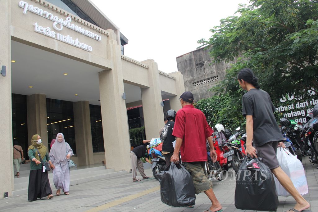 Sejumlah pedagang kaki lima membawa barang dagangan mereka ke tempat relokasi yang diberi nama Teras Malioboro I di kawasan wisata Malioboro, Kota Yogyakarta, Selasa (1/2/2022). 
