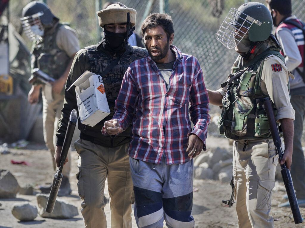 Polisi India menahan seorang warga Kashmir dalam unjuk rasa yang berakhir dengan bentrokan.
