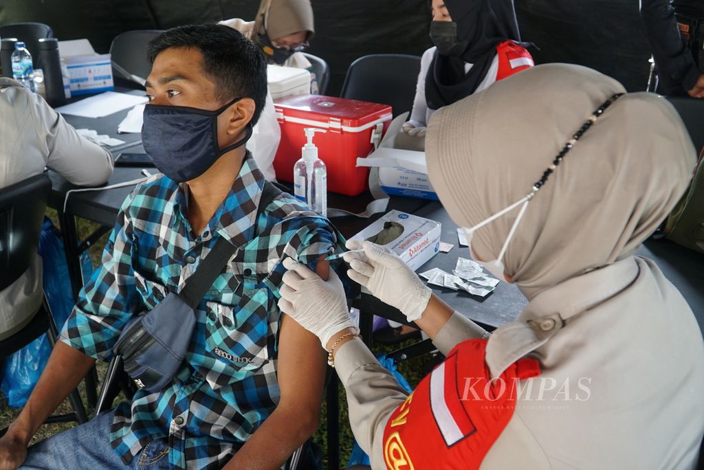 Petugas menyuntikkan vaksin Covid-19 kepada warga di Lapangan Imam Bonjol, Padang, Sumatera Barat, Sabtu (19/6/2021). Vaksinasi massal yang diadakan Polda Sumbar dan Polresta Padang ini menyasar warga usia 18 tahun ke atas.