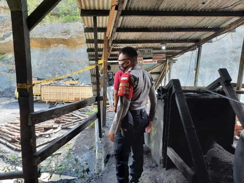 Polisi memasang tali garis polisi di sekitar lubang tambang batubara CV Tahiti Coal, Desa Sikalang, Kecamatan Talawi, Kota Sawahlunto, Sumatera Barat, Sabtu (12/9/2020). Reruntuhan lubang tambang di kedalaman 150 meter pada Sabtu subuh menyebabkan 3 pekerja meninggal dan 1 pekerja luka berat.