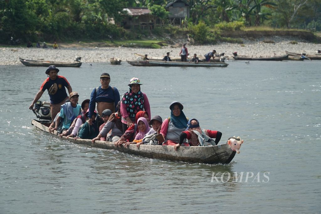 Para pekerja perusahaan perkebunan kelapa sawit menyeberang pulang kerja menumpang perahu ketek di Sungai Muar, Desa Serami Baru, Kecamatan Malin Deman, Kabupaten Mukomuko, Bengkulu, Sabtu (3/6/2023) siang. 