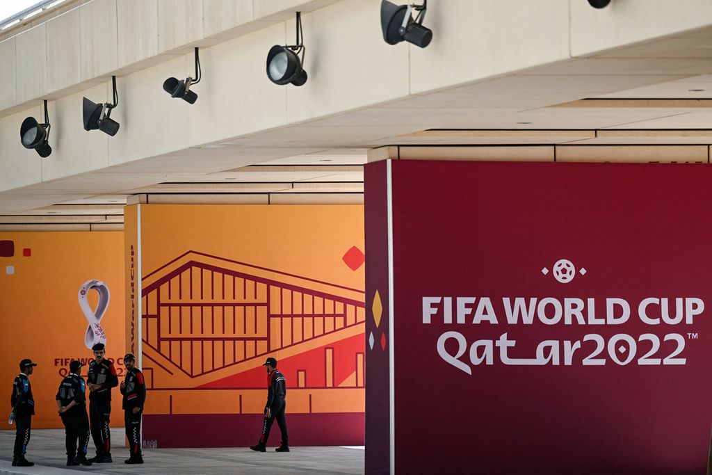 Polisi berjaga di dinding pariwara Piala Dunia Qatar 2022 di luar Main Media Center, Doha, Qatar, 3 November 2022. Jelang pembukaan turnamen pada 18 November 2022, Qatar menghadap kritik dan skeptisisme antara lain kematian buruh migran dan hak-hak kaum LGBT.