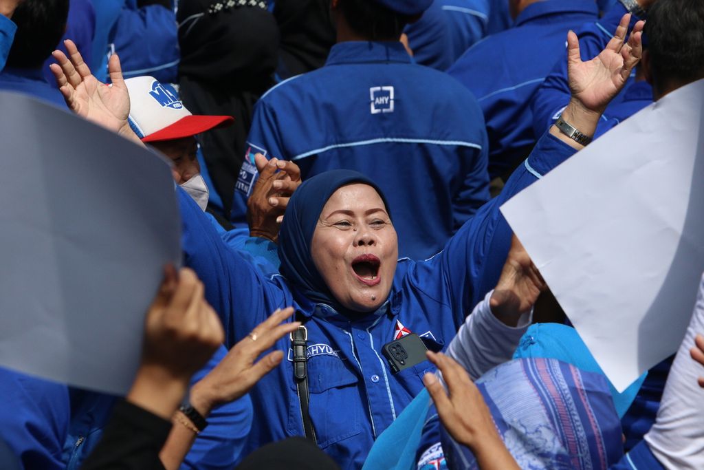 Seorang sukarelawan bersemangat meneriakkan yel-yel ketika menyambut kedatangan Anies Baswedan di halaman kantor DPP Partai Demokrat, Kelurahan Pegangsaan, Kecamatan Menteng, Jakarta Pusat, Jumat (7/10/2022). 