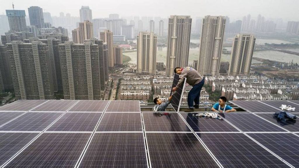 Pekerja Wuhan Guangsheng Photovoltaic mengerjakan proyek panel surya di atap sebuah gedung bertingkat 47 di Wuhan, China, Senin (15/5/2016).
