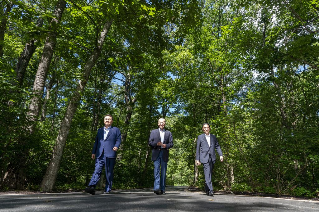 Presiden Amerika Serikat Joe Biden (tengah), berjalan bersama mitranya Presiden Korea Selatan Yoon Suk Yeol (kiri) dan Perdana Menteri Jepang, Fumio Kishida (kanan) di Camp David pada Jumat (18/8/2023).