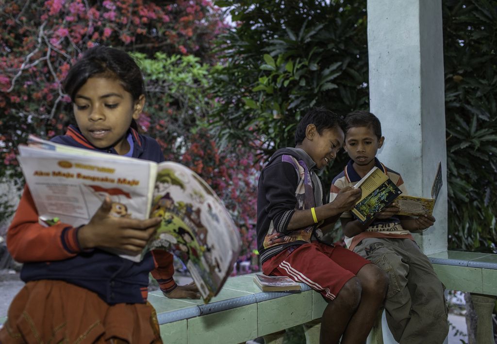 Children read books at the Lakoat.Kujawas library in Taiftob Village, North Mollo, South Central Timor, East Nusa Tenggara.