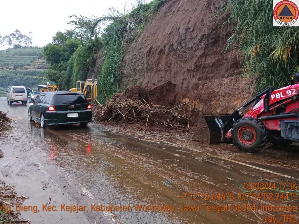 Kendaraan melintasi jalan yang baru dibersihkan dari material longsor di jalur Wonosobo-Dieng, Kecamatan Kejajar, Kabupaten Wonosobo, Jawa Tengah, Minggu (3/3/2024) sore. Longsor di jalur wisata ini menimbulkan kemacetan lebih dari tiga jam.