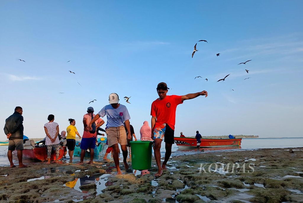 Warga membawa ember berisi ikan teri tangkapan nelayan dari bagan di sekitar perairan Kampung Nelayan Selayar, Kecamatan Manyeuw, Kabupaten Maluku Tenggara, Provinsi Maluku, Minggu (17/9/2023). 