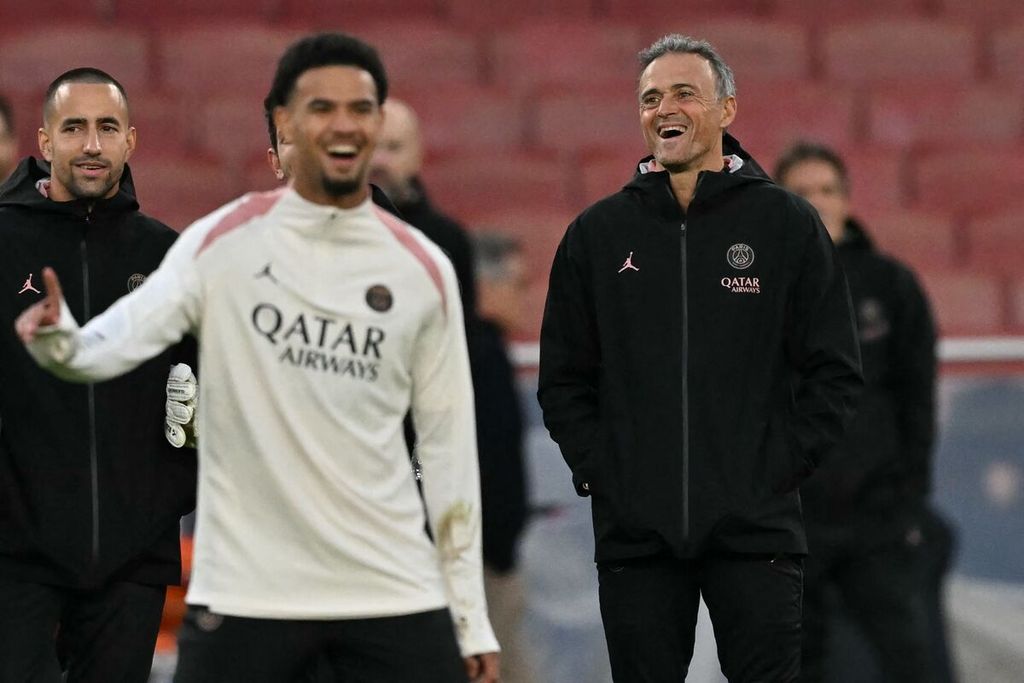 Pelatih Paris Saint-Germain Luis Enrique (kanan) tersenyum saat mengawasi sesi latihan pemainnya di Stadion Emirates, London, Inggris, Senin (30/9/2024). PSG akan menghadapi Arsenal dalam laga Liga Champions.