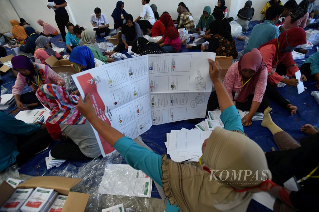 Pekerja melakukan pemeriksaan serta pelipatan surat suara di Gresik, Jawa Timur, Senin (25/2/2019). KPU Kabupaten Gresik membagi lokasi pelipatan di dua tempat. Di tempat itu sendiri dilakukan pelipatan kertas suara sebanyak 2.836.758 kertas suara.