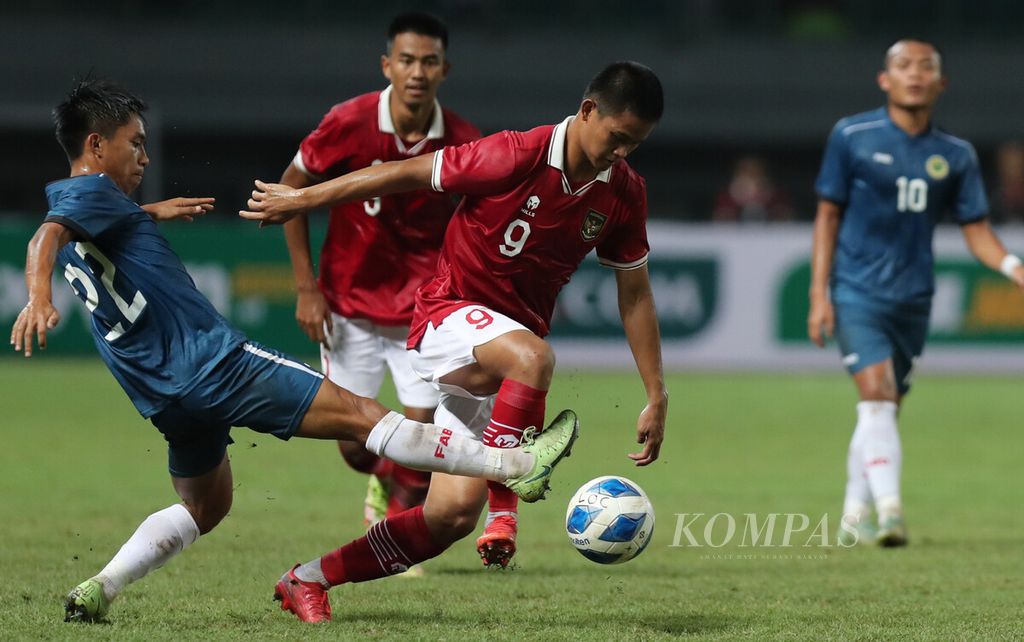 Pemain Tim Nasional Indonesia U-19 Hokky Caraka (tengah) melepaskan diri dari kawalan bola pemain Tim Nasional Brunei Darussalam Mohd Syaherrul Affendy (kiri) dalam laga penyisihan Grup A Piala AFF U19 2022 di Stadion Patriot Chandrabhaga, Bekasi, Jawa Barat, Senin (4/7/2022).Skuad asuhan Shin Tae-yong itu berhasil mencetak tujuh gol tanpa balas. Hasil tersebut menempatkan Indonesia melesat ke posisi 2 Grup A.