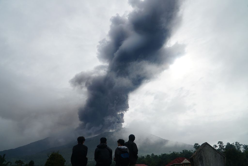 Para pemuda menyaksikan kolom abu yang keluar dari kawah Gunung Marapi di Posko Utama SAR, tak jauh dari Kantor Wali Nagari Batupalano, Kecamatan Sungai Pua, Agam, Sumatera Barat, Senin (4/12/2023). Kawah Marapi masih mengeluarkan asap dan abu vulkanik sejak pertama kali erupsi pada Minggu (3/12/2023) pukul 14.54.