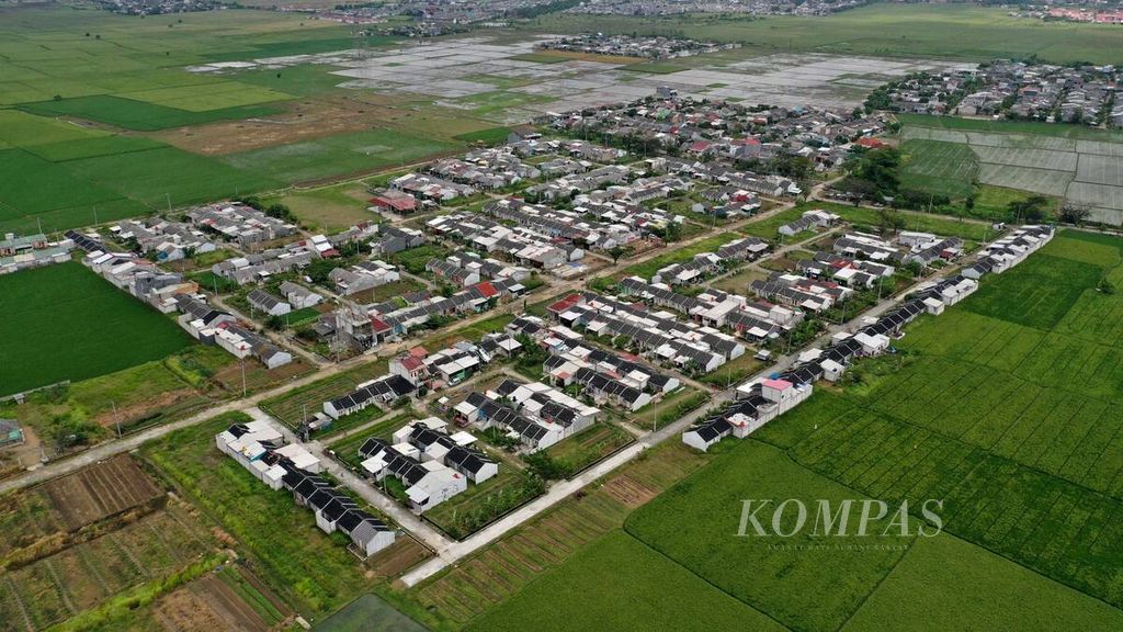 Foto udara kluster hunian di tengah areal persawahan di Kecamatan Tambun Utara, Kabupaten Bekasi, Jawa Barat, Kamis (16/7/2020). Berkurangnya lahan pertanian dan situ memperparah banjir yang tiap tahun terjadi. 