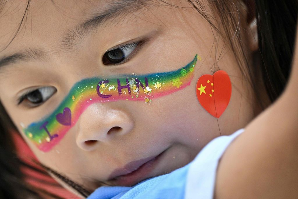 Seorang anak dengan cat wajah terlihat di Museum Kongres Nasional Pertama Partai Komunis China pada Hari Nasional China, yang menandai peringatan 75 tahun berdirinya Republik Rakyat Tiongkok, di Shanghai pada 1 Oktober 2024.