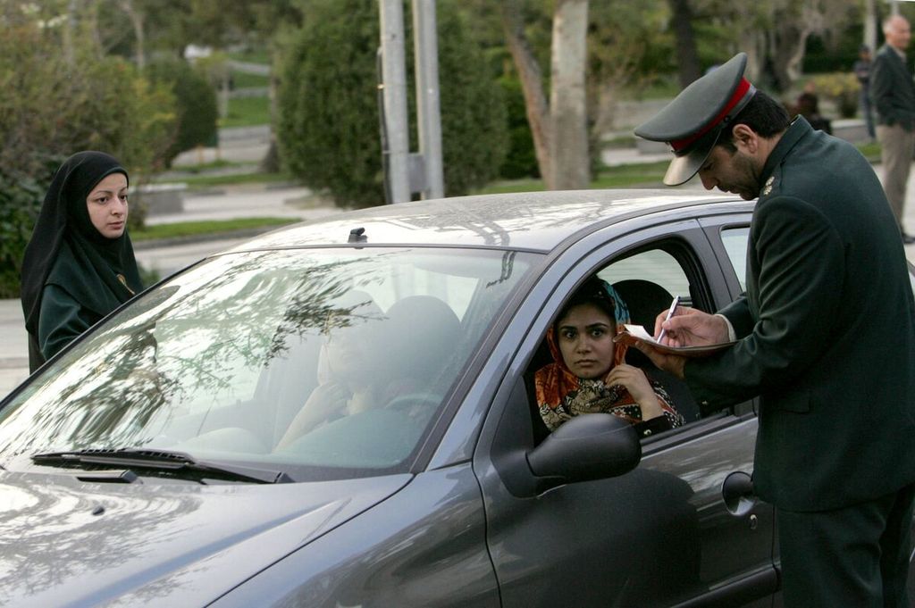 Dalam foto dokumentasi tanggal 22 April 2007 ini, terlihat polisi Iran menghentikan sebuah kendaraan dalam operasi pemberlakuan aturan berpakaian Islam di utara Teheran. 