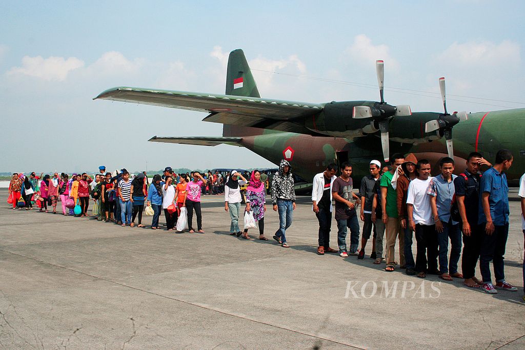 Sebanyak 129 tenaga kerja Indonesia (TKI) ilegal asal Jawa Timur yang bekerja di Malaysia tiba dengan pesawat Hercules di Lapangan Udara AL Surabaya, Jawa Timur, Rabu (24/12/2014). 