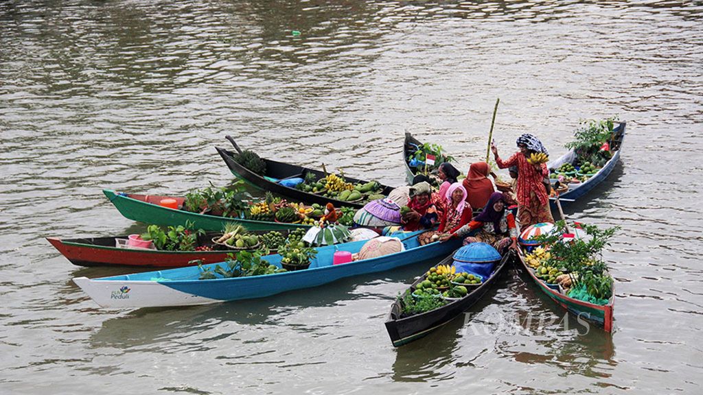 Para pedagang pasar terapung membentuk formasi dalam atraksi jukung atau perahu di Sungai Martapura, Kota Banjarmasin, Kalimantan Selatan, Jumat (25/8/2017) sore. 