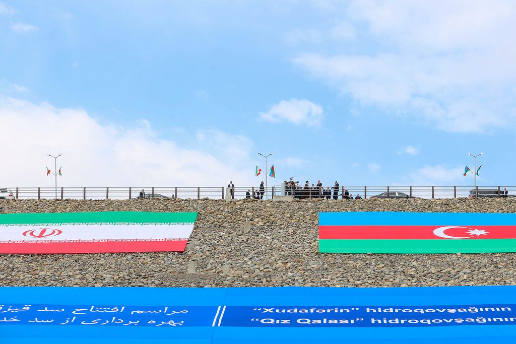 Foto dari Kantor Kepresidenan Iran pada 19 Mei 2024 memperlihatkan bendera Iran dan Azerbaijan dibentangkan di bendungan Qiz Qalasi di Sungai Aras yang dibangun bersama kedua negara. 