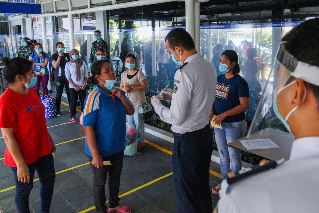 Petugas Kantor Imigrasi Kelas I Khusus Batam memeriksa kelengkapan dokumen para pekerja migran Indonesia di Pelabuhan Internasional Batam Centre, Kota Batam, Kepulauan Riau (21/5/2020).