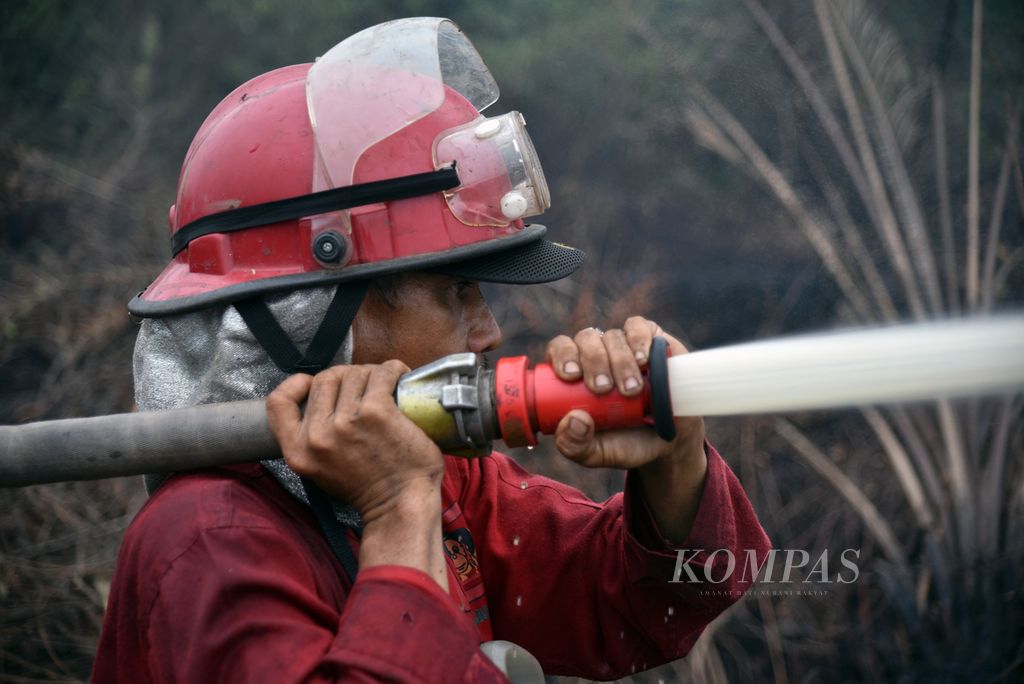 Anggota Manggala Agni dari Daerah Operasi Sumatera XVI/Lahat Anson (43) mengendalikan nozel saat memadamkan kebakaran lahan gambut di Desa Jungkal, Kecamatan Pampangan, Ogan Komering Ilir, Sumsel, Selasa (7/11/2023). 