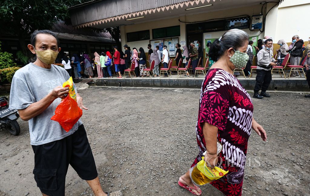 Warga membawa minyak goreng kemasan 2 liter yang ia beli di operasi pasar minyak goreng oleh Polres Metro Jakarta Selatan di GOR BRI Radio Dalam, Jakarta Selatan, Senin (7/3/2022). Setiap warga hanya dapat membeli maksimal 2 liter dengan harga Rp 14.000 per liter. Sebanyak 7.200 liter minyak goreng dijual pada operasi pasar tersebut.