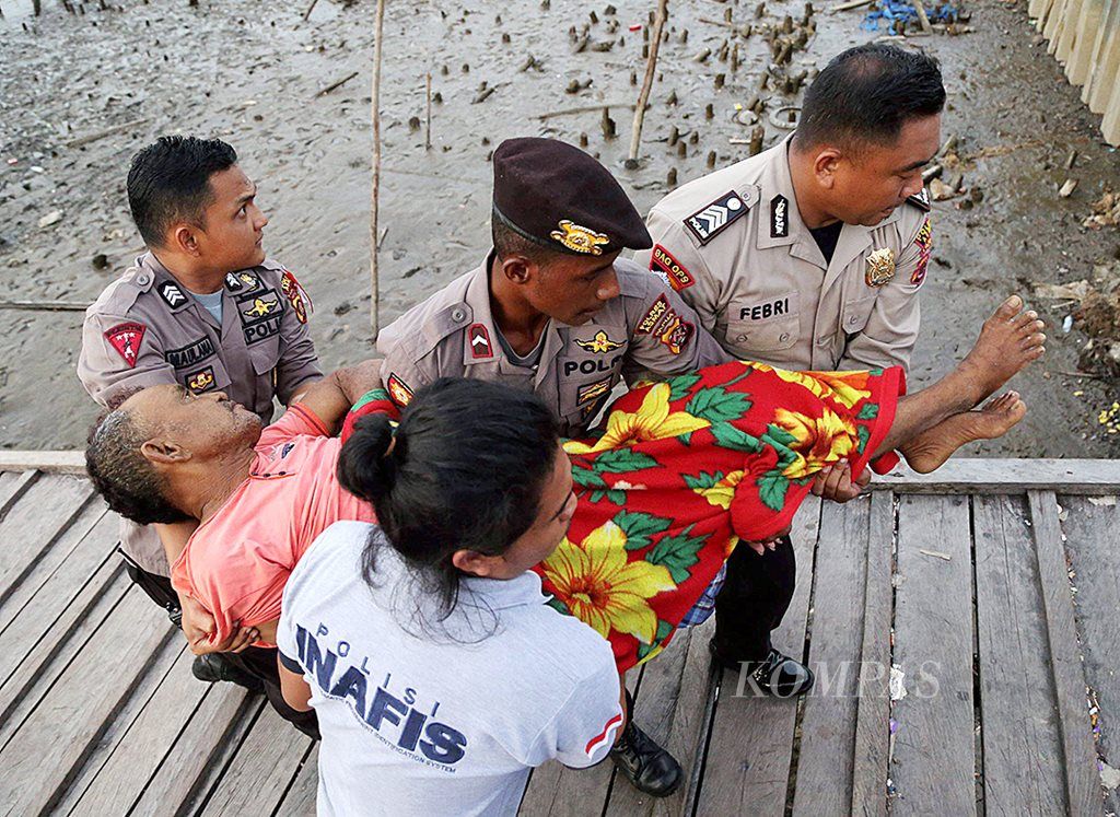Polisi membantu mengangkat warga yang sakit dan dirujuk ke Rumah Sakit Umum Daerah Agats, Kabupaten Asmat, Papua, Jumat (19/1).