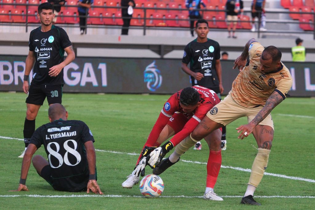 Pesepak bola Arema FC, Gustavo (kanan), berebut bola dengan kiper PSS Sleman, Muhammad Ridwan, dalam lanjutan BRI Liga 1 di Stadion Kapten I Wayan Dipta, Gianyar, Bali, Sabtu (30/9/2023). Arema FC mengalahkan PSS Sleman dengan skor 2-1.