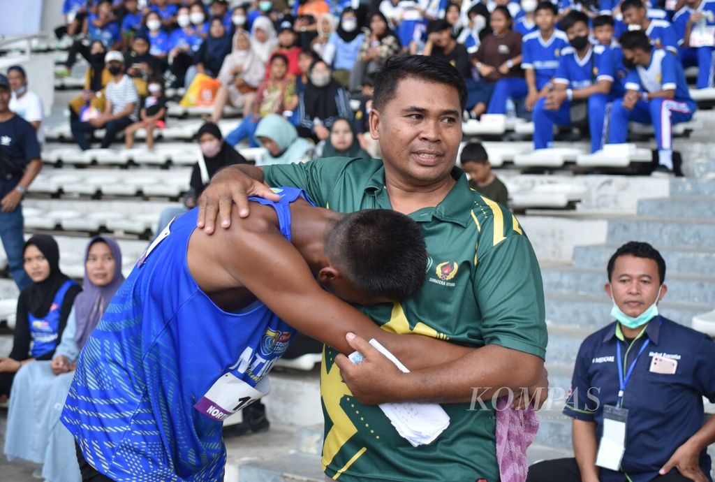 Atlet Firli Sahputra (kiri) menangis terharu seusai memenangi final lompat jauh di hari terakhir putaran final Student Athletic Championship (SAC) Indonesia 2023 di Stadion Madya Senayan, Jakarta, Jumat (13/1/2023). 